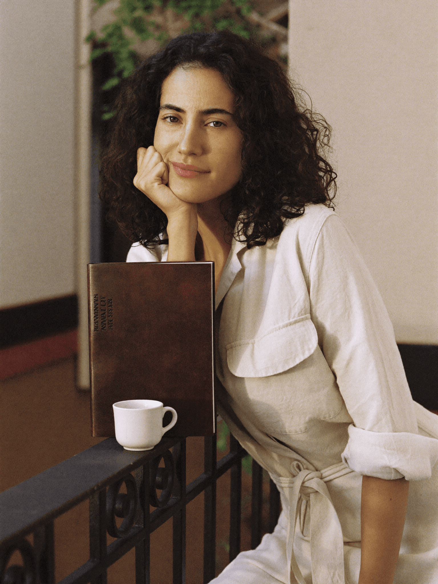 Sofia, A2 learner, in cream linen on a sunlit Valencia balcony